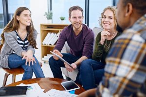 Quatre jeunes adultes en train de discuter de change mangement dans un espace de travail