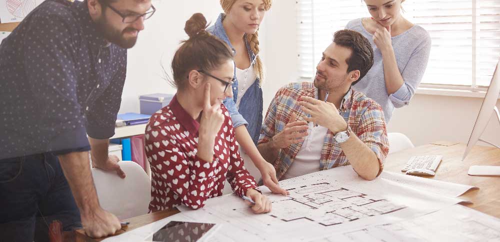 Collègues discutant autour d'un plan de Test Fit Go to the Point